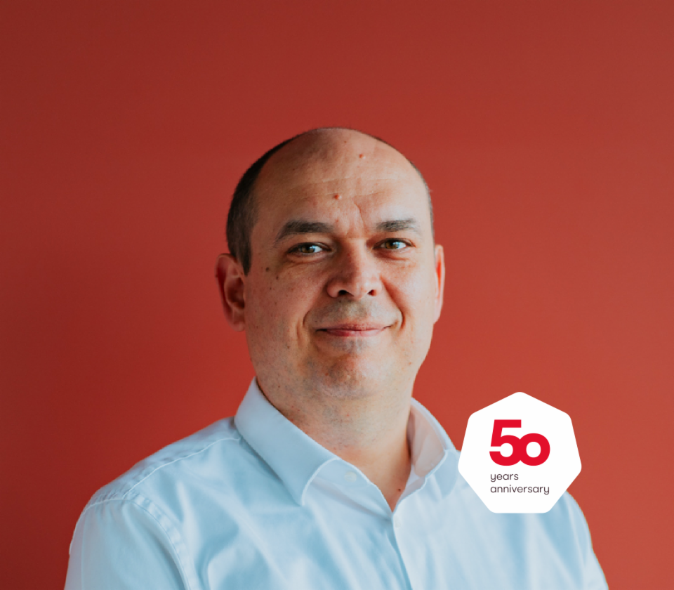 Retrato de Cristian Musat, director general de EOS Technology Solutions delante de un fondo rojo