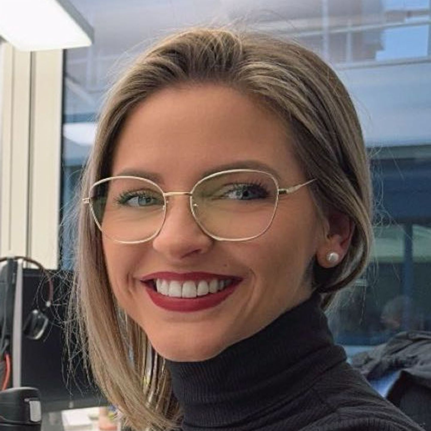 Genny Bollinger, especialista en reestructuración de deuda de EOS en Suiza, está sentada en su escritorio con un suéter de cuello alto gris y sonriendo a la cámara.