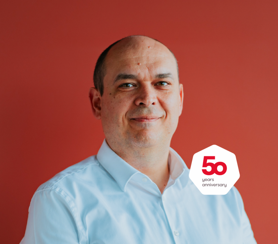 Retrato de Cristian Musat, director general de EOS Technology Solutions delante de un fondo rojo