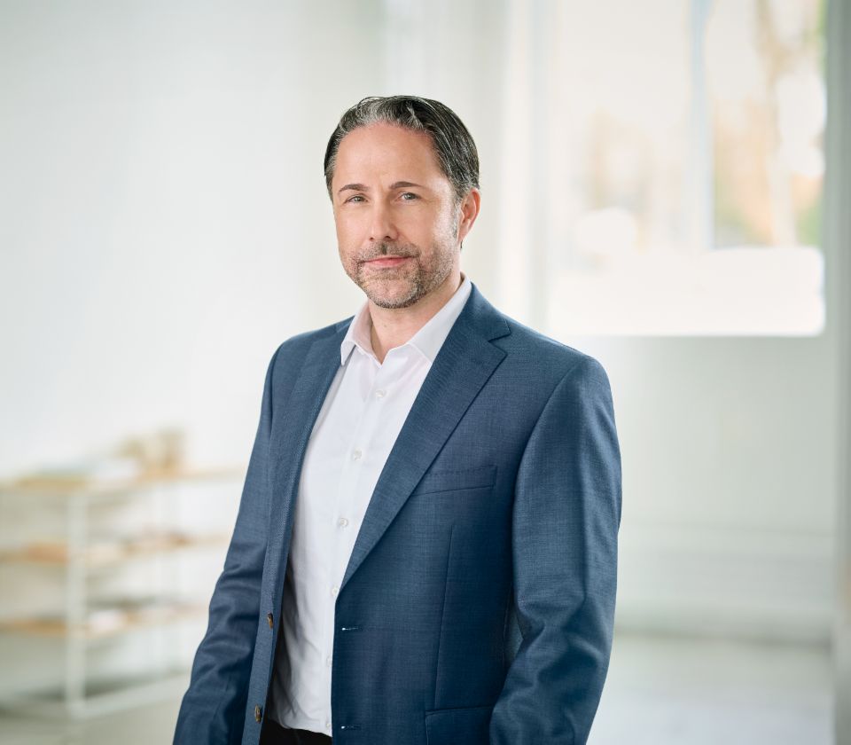 Retrato de Marwin Ramcke, presidente de la Junta Directiva del Grupo EOS, vestido con una americana oscura en una estancia con mucha luz 
