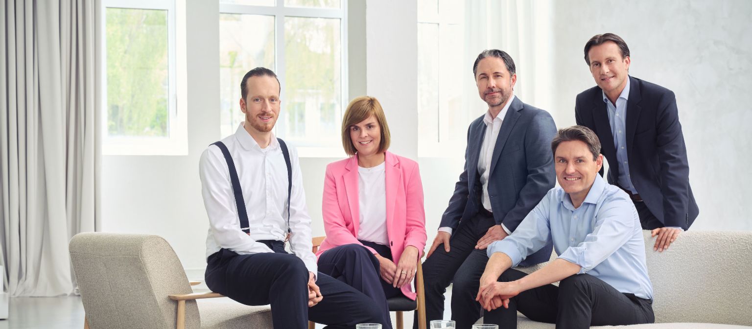 Junta Directiva del Grupo EOS (de izquierda a derecha: Sebastian Pollmer, Dr. Eva Griewel, Marwin Ramcke, Dr. Stephan Ohlmeyer y Carsten Tidow), en una estancia con mucha luz mirando a la cámara