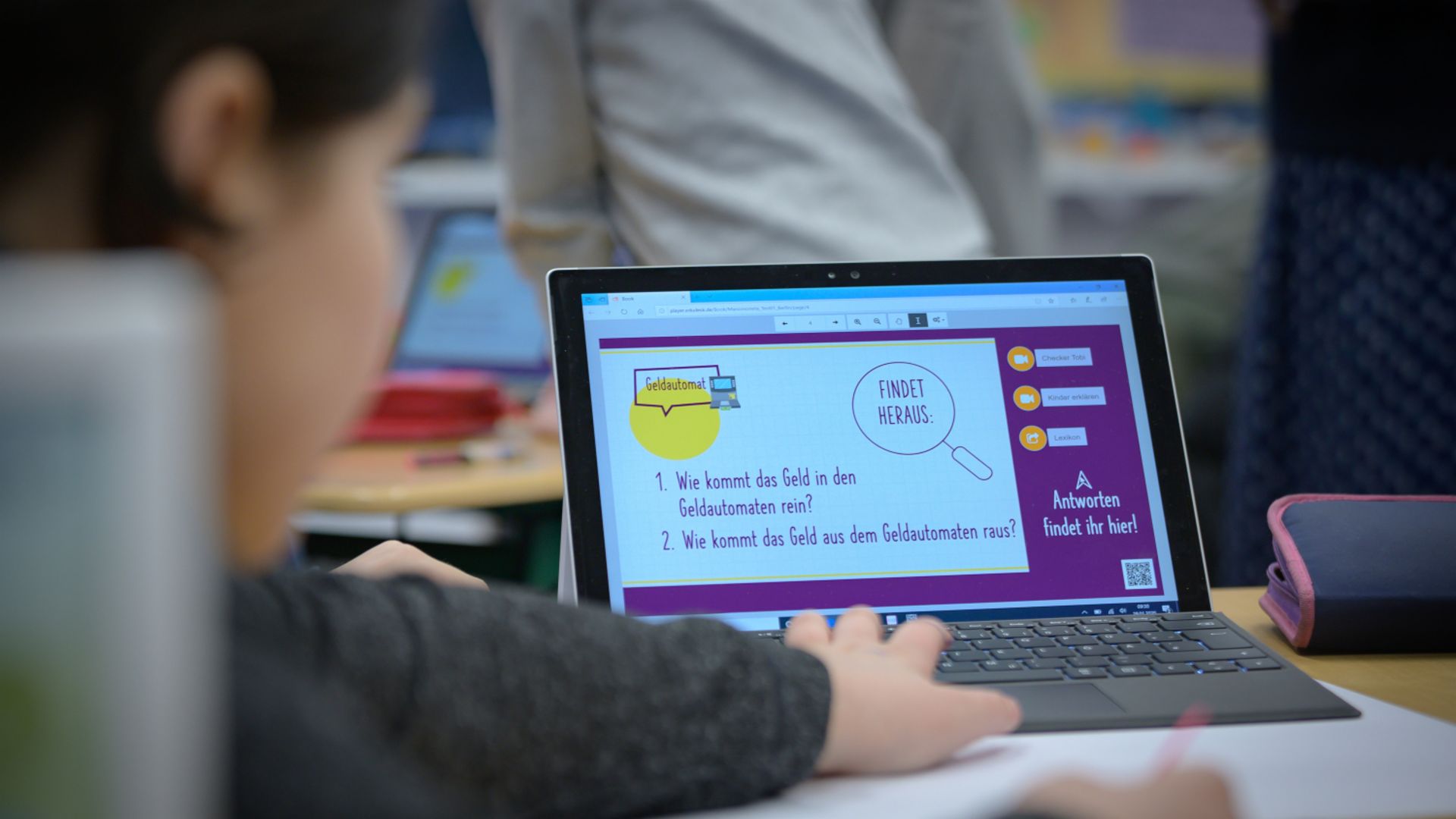 Financial education for children: Child sits at laptop and learns something about finances.